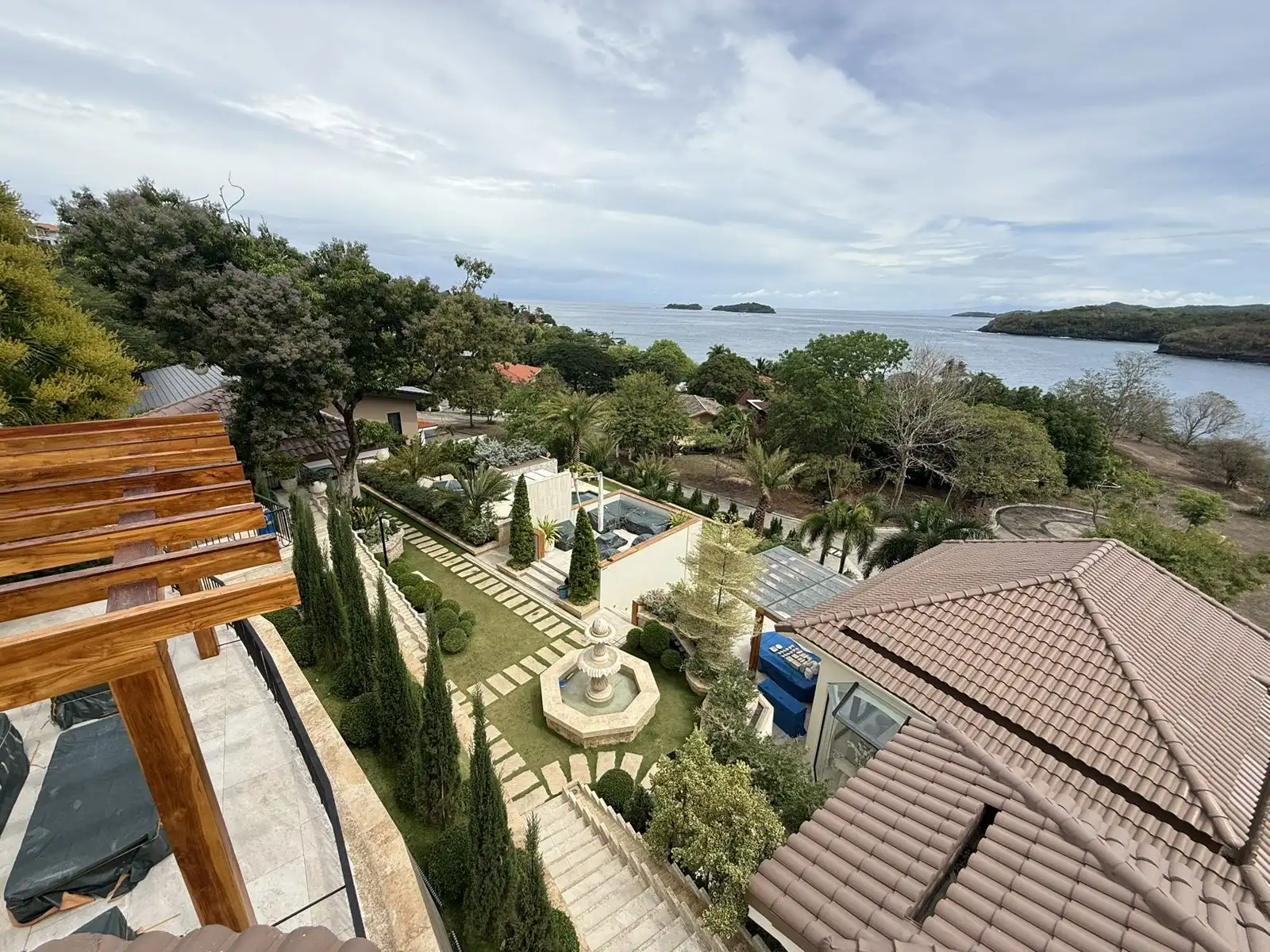 Elevated view of a formal fountain garden with the bay and offshore islands beyond