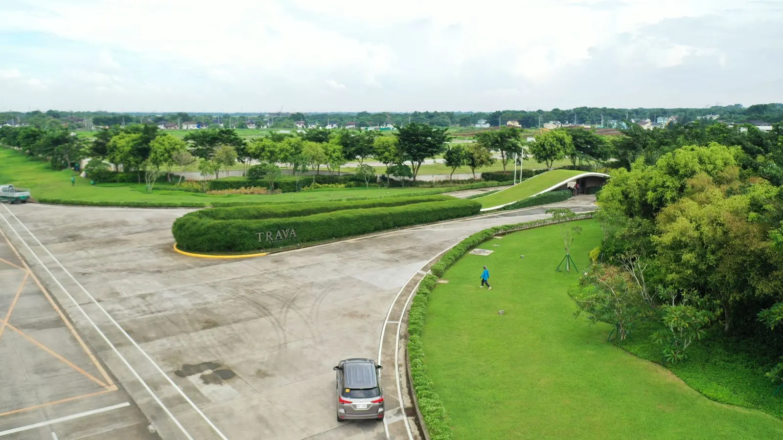 Aerial view of the finished Trava community entrance with palm-lined boulevard and manicured medians