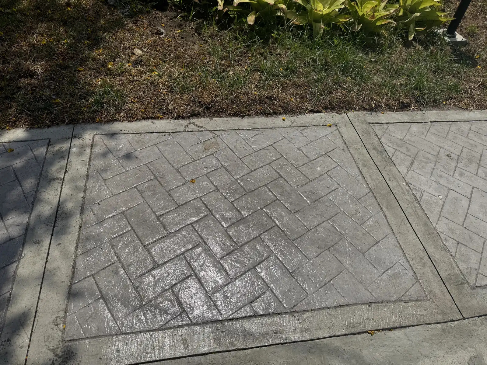 Close-up of a herringbone-pattern stamped concrete sidewalk medallion, Terraces at Tradizo