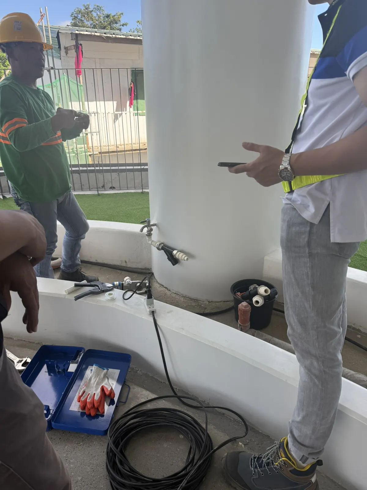 MEG crew installing an irrigation valve and manifold at a cistern, De La Salle University Laguna campus