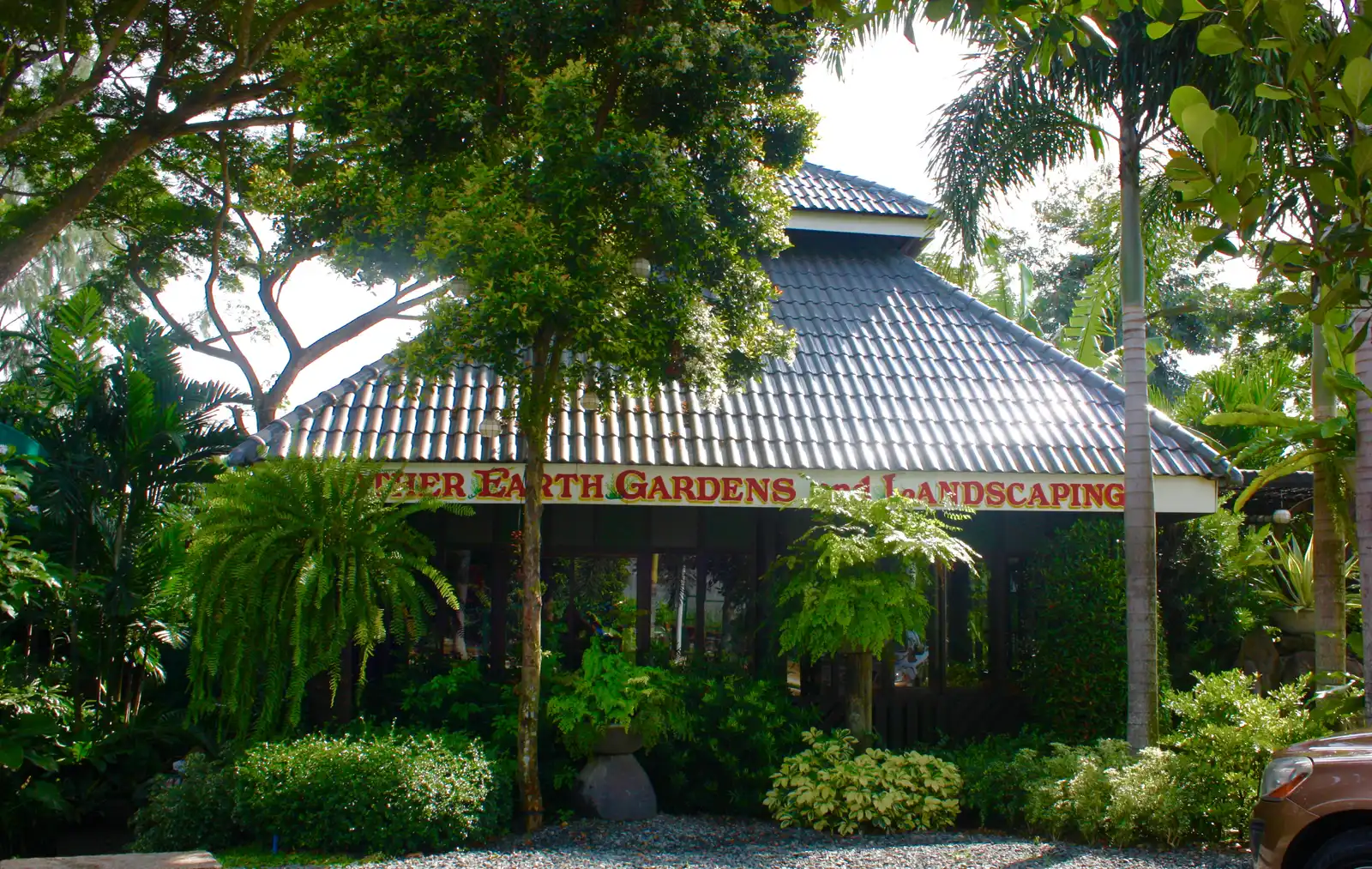 Trees and garden planting fronting a building facade, Silang showcase garden
